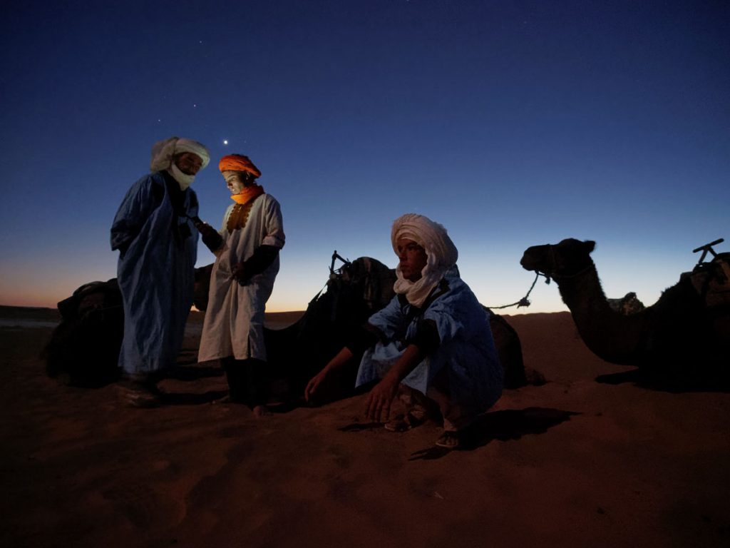 David H. Wells: Camel Drivers at Sunset, Morocco